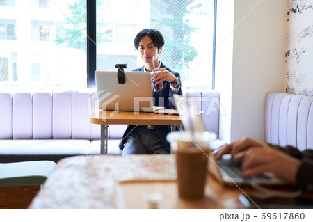 カフェで仕事をする男性 69617860