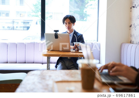 カフェで仕事をする男性 69617861