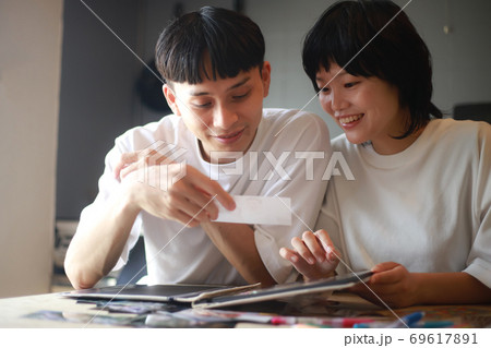 写真を見るカップル 69617891