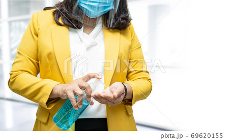 New Normal, Asian working woman washing hand by alcohol sanitizer gel protect Covid-19 Coronavirus. New Normal, Asian working woman washing hand by alcohol sanitizer gel protect Covid-19 Coronavirus. 69620155