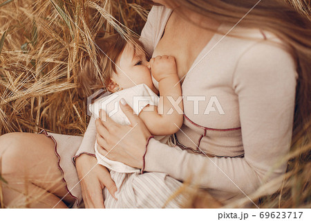 Elegant mother with cute little daughter in a field 69623717