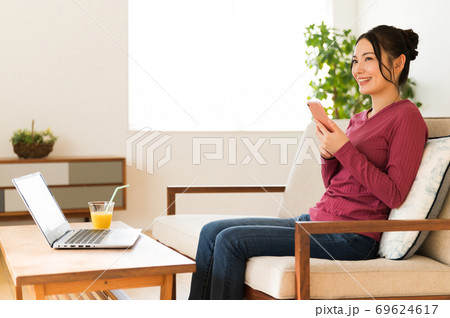 テレワークの合間にスマホで一息入れる女性 テレワークの合間にスマホで一息入れる女性 69624617