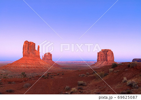 The last rays of the setting sun illuminate famous Buttes of Monument Valley 69625087