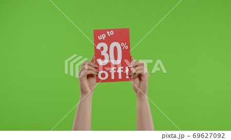 Up To 30 Percent Off advertisement inscription on paper sheet in womans hands on chroma key 69627092