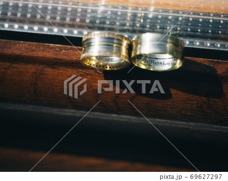 Engraved wedding rings on the wooden window 69627297