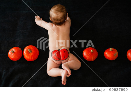 baby ass with painted pumpkin on black background 69627699