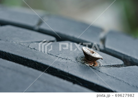 Close up metal screws nails embroidered in tires. 69627982