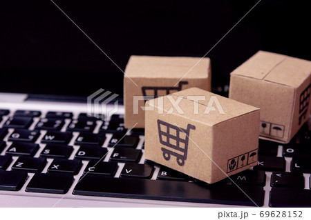 Shopping online. Cardboard box with a shopping cart logo on laptop keyboard. Shopping service on The online web. offers home delivery. 69628152