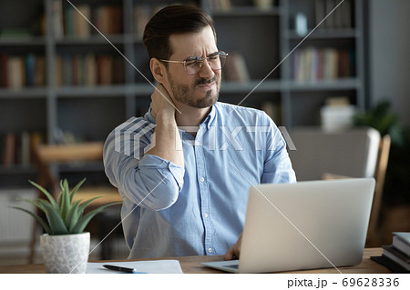 Unhealthy young man massage neck suffering from back spasm 69628336