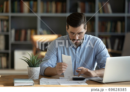Focused man calculate household finances at home Focused man calculate household finances at home 69628385