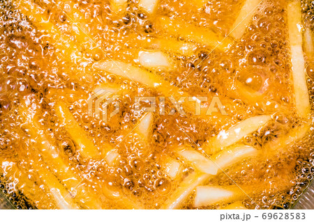 French fries on the pan, close up. Fried potatoes in oil. 69628583