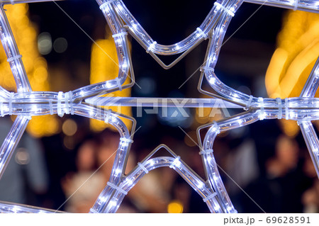 s neon lights in the shape of snowflakes lights on the square in the night.  69628591
