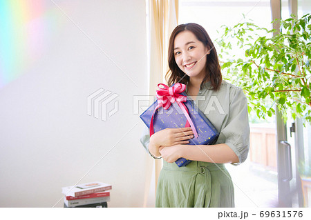 プレゼントの箱を持つ笑顔の女性 プレゼントの箱を持つ笑顔の女性 69631576