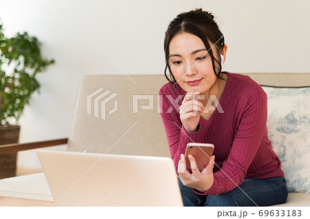 パソコンとスマホを操作しながらコンテンツを視聴する女性 パソコンとスマホを操作しながらコンテンツを視聴する女性 69633183