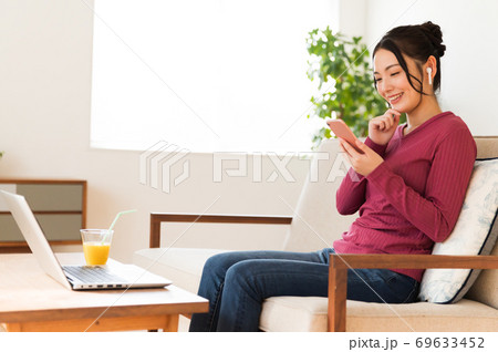 テレワークの合間に音楽を視聴する女性 69633452
