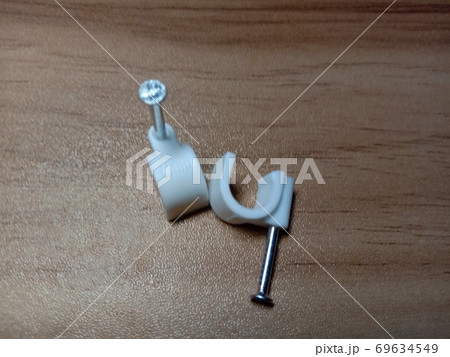 white colored wire pin on wooden table white colored wire pin on wooden table 69634549