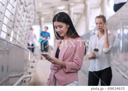 Charming young woman looking at smartphone in her hands. Businesswoman use cellphone Charming young woman looking at smartphone in her hands. Businesswoman use cellphone 69634635