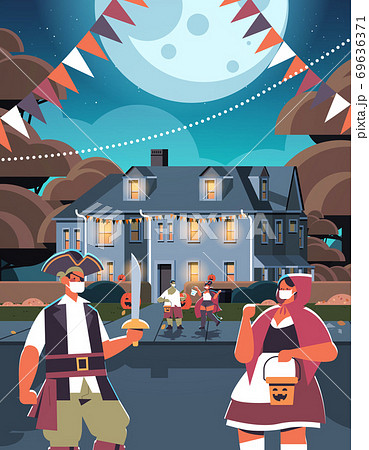 mix race people in costumes walking in town trick or treat happy halloween celebration coronavirus quarantine 69636371