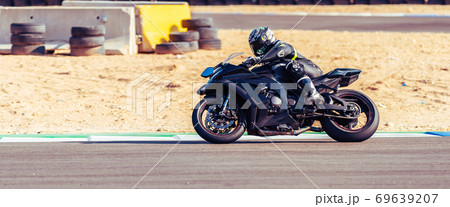 motorcycle racer rides on a sports track motorcycle racer rides on a sports track 69639207