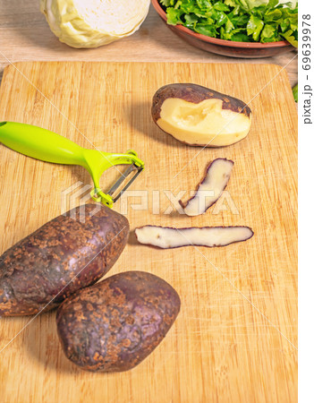peeling potatoes on a wooden table peeling potatoes on a wooden table 69639978