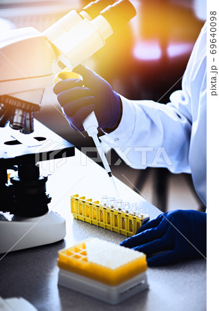 Variable volume multichannel pipette. Medical worker, scientist, laboratory assistant works in the laboratory Variable volume multichannel pipette. Medical worker, scientist, laboratory assistant works in the laboratory 69640098