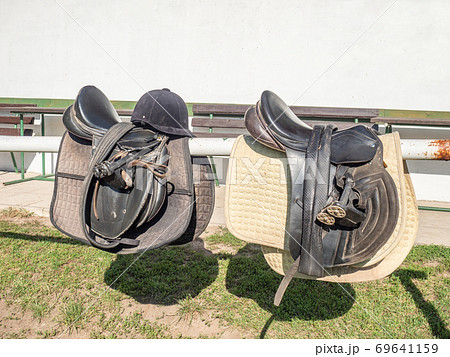 Leather saddle on mooring beam with stirrups. Children ridding school Leather saddle on mooring beam with stirrups. Children ridding school 69641159