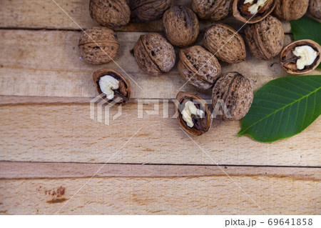 Walnuts and leaves on a wooden table. Walnuts and leaves on a wooden table. 69641858