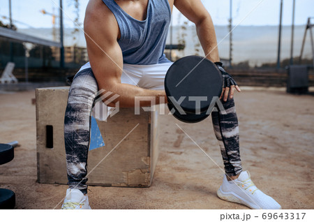 Man doing exercise with dumbbell, street workout Man doing exercise with dumbbell, street workout 69643317