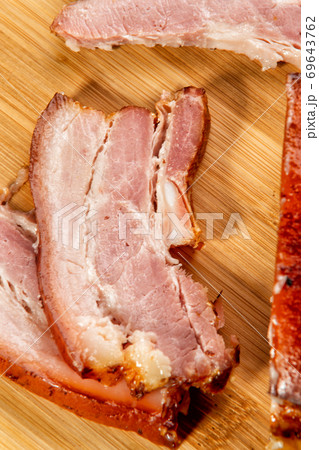 smoked meat cut into slices lies on a wooden table smoked meat cut into slices lies on a wooden table 69643762