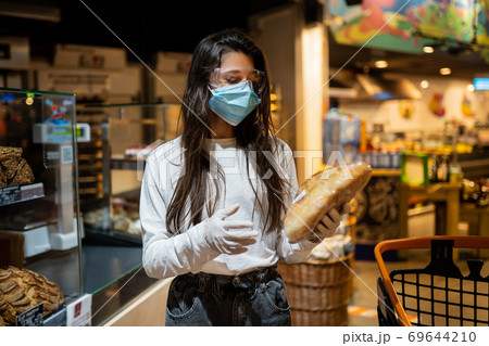 The girl with surgical mask is going to buy bread. The girl with surgical mask is going to buy bread. 69644210