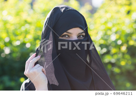 A migrant woman from the east in black clothes. A migrant woman from the east in black clothes. 69646211