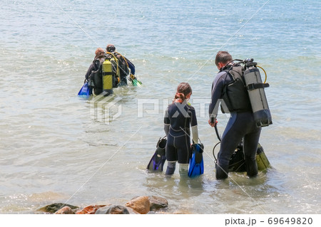 divers enter the water on the beach 69649820