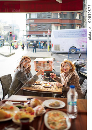 Two girlfriends sitting in a cafe and drink tea 69650377
