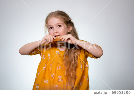 The little girl eating the pizza and laughing. The little girl eating the pizza and laughing. 69653200
