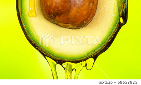 Fresh cut avocado with oil stream. Fresh cut avocado with oil stream. 69653925
