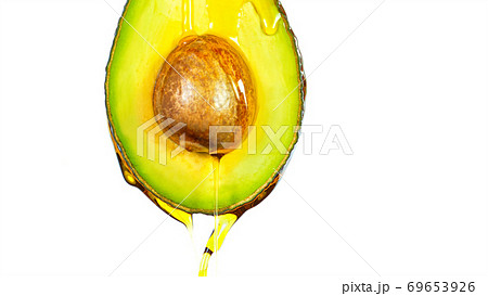 Fresh cut avocado with oil stream. Fresh cut avocado with oil stream. 69653926