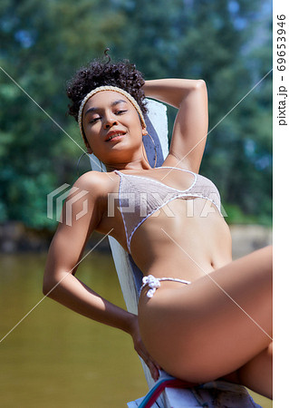 Asian model in bikini posing with old fishing boat Asian model in bikini posing with old fishing boat 69653946
