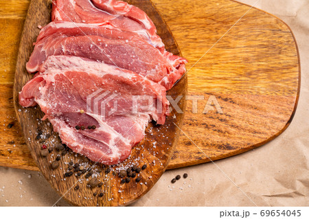 pork on wooden Board with salt, pepper free space  69654045
