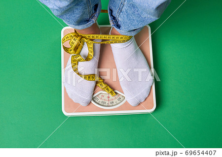 Close-up feet with socks standing on scales. 69654407