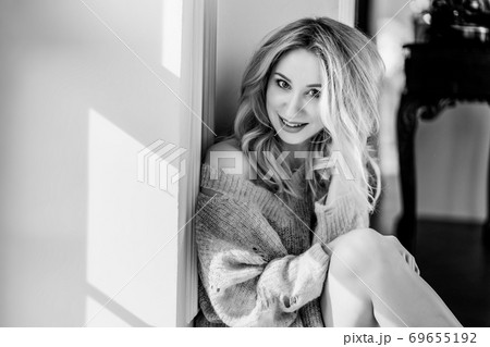 beautiful blonde girl in pink sweater sits 69655192