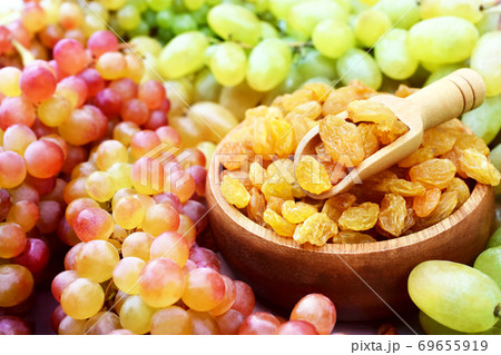Dried yellow raisins in wooden spoon with fresh ripe grapes, selective focus 69655919