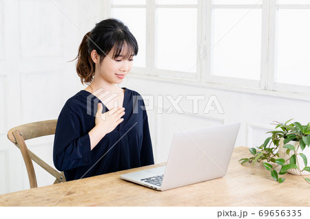 胸に手を当てる若い女性 69656335
