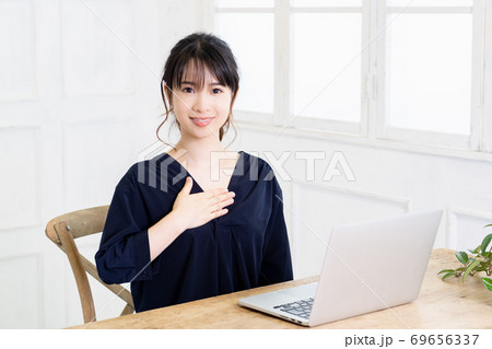 胸に手を当てる若い女性 69656337