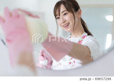 洗面所で鏡を掃除する若い女性　除菌 69657298