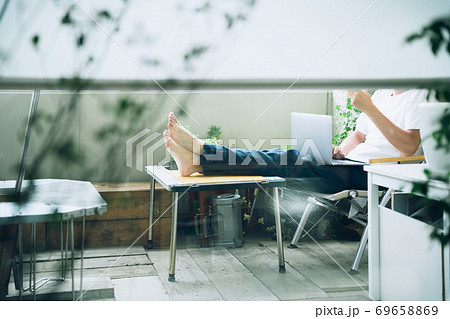 自宅のベランダでリモートワークする男性（顔無し） 69658869
