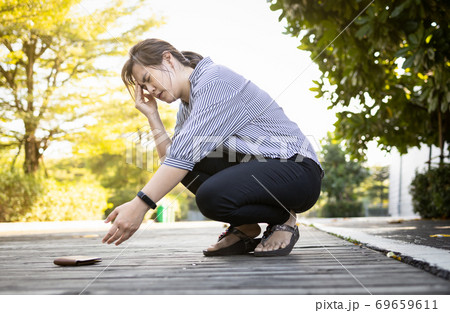 Exhausted asian woman suffer from headache,migraine,tired female people having vertigo,feel dizzy,fatigue,fainted while stooping down,reached towards her wallet that had fallen on floor,health care 69659611