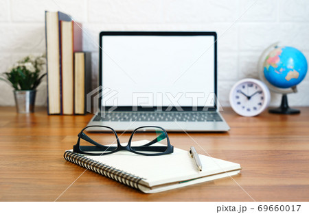 Workplace with notepad and laptop on table at home Workplace with notepad and laptop on table at home 69660017