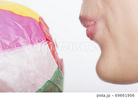 紙風船を膨らます女性の口元 69661906