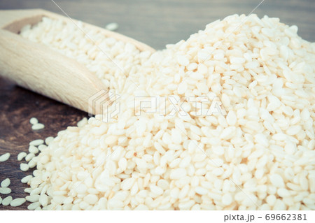 Vintage photo, Heap of sesame seeds with wooden scoop on board Vintage photo, Heap of sesame seeds with wooden scoop on board 69662381