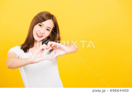 woman teen smile standing make finger heart figure symbol shape sign with two hands 69664400